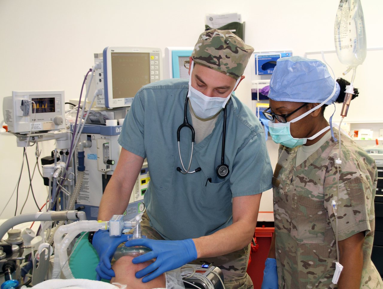 A physician anesthesiologist administering general anesthesia to a patient in an operating room