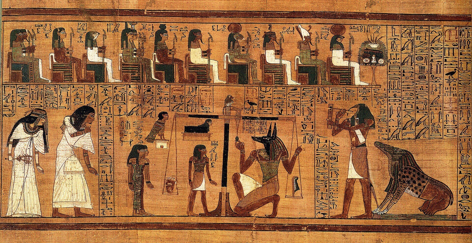 A painted papyrus in two registers on a tan ground. Above, a row of about ten deities seated on thrones, several with animal heads, with columns of hieroglyphs between them and an offering stand at the right end. Below, from the left: two figures in white linen stepping right, then a tall balance with a black upright and two hanging pans, one holding a small dark object and the other a small upright shape, with a small baboon-like figure perched on top. A jackal-headed figure crouches at the base of the scales. A standing figure holds a writing board and stylus. At the far right crouches a composite creature with a crocodile-like head, a spotted feline forepart and heavy hindquarters.