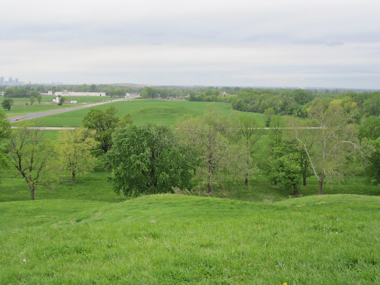 The view from the summit of Monks Mound looking west toward St. Louis, with the Cahokia Woodhenge site visible at the far edge of the field