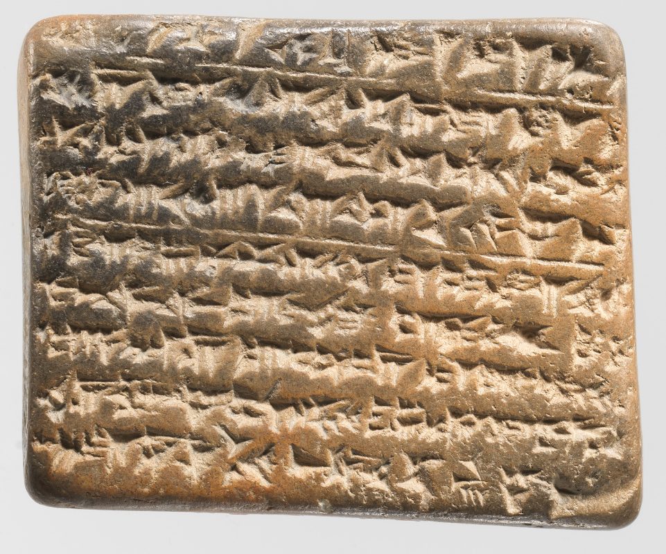 A small fragment of a clay tablet covered in wedge-shaped cuneiform script