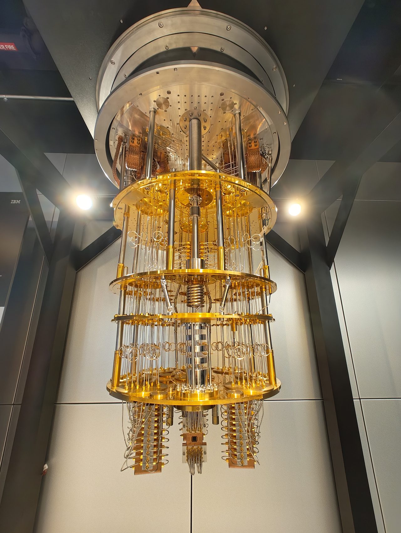 A tiered, gold chandelier-shaped dilution refrigerator used to cool a superconducting quantum processor
