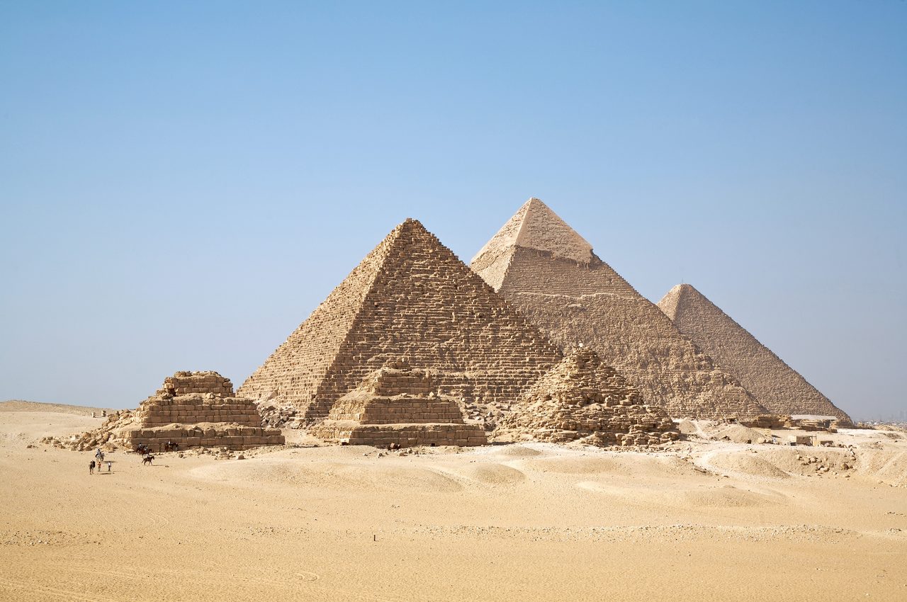 Aerial view of the three main pyramids of Giza in their characteristic diagonal line, with the Great Pyramid of Khufu closest