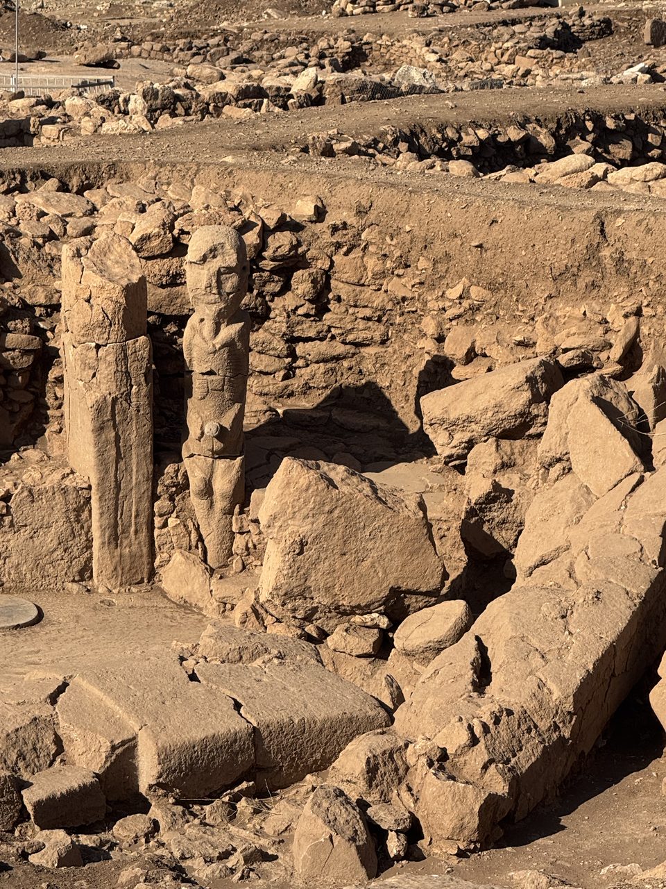 The September 2023 carved human figure from Karahan Tepe, standing where it was found, with a distinct head and a hand at the groin