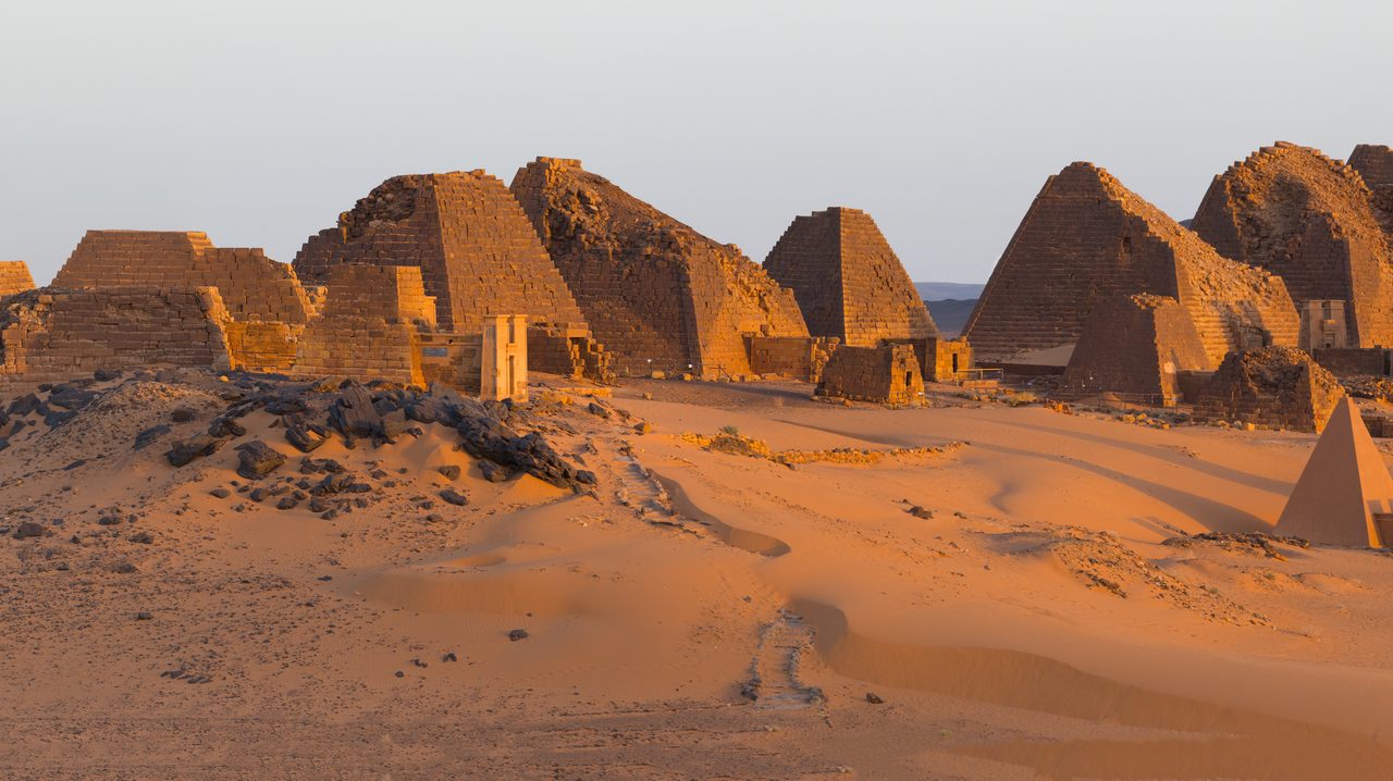 The steep-angled pyramids of Meroe standing in the desert at sunrise, Sudan