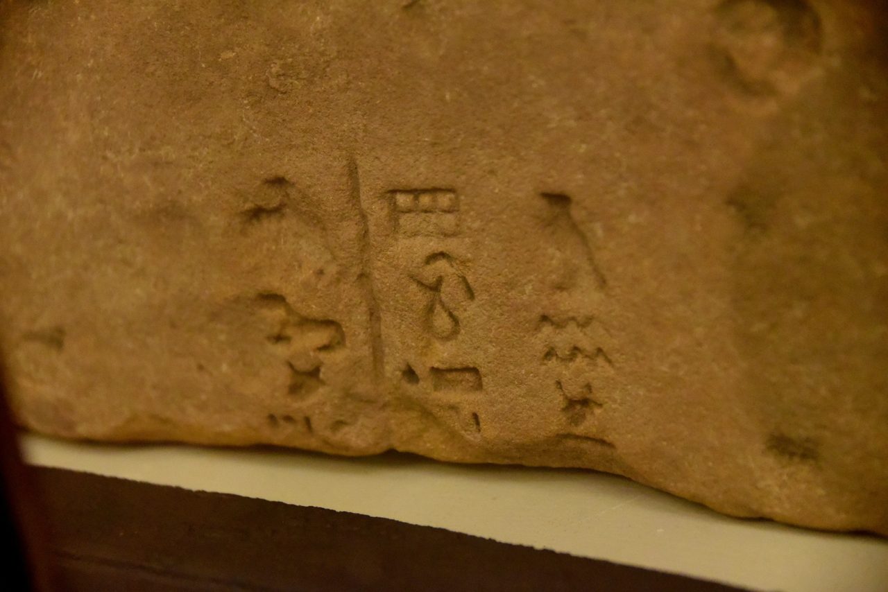 A sandstone fragment bearing Meroitic hieroglyphic inscriptions in three vertical columns, from Meroe
