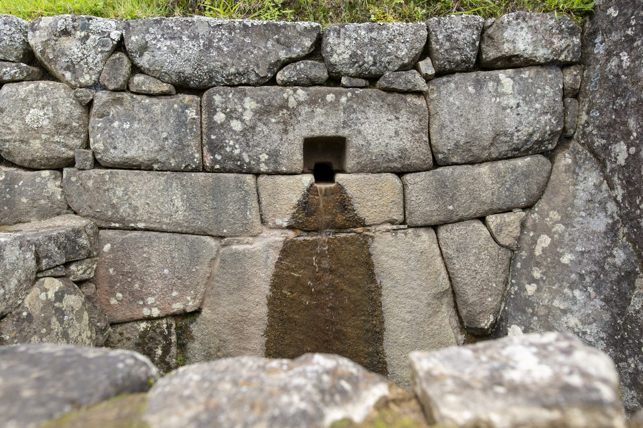 A close view of one of the carved stone fountains at Machu Picchu, part of the 16-fountain cascade