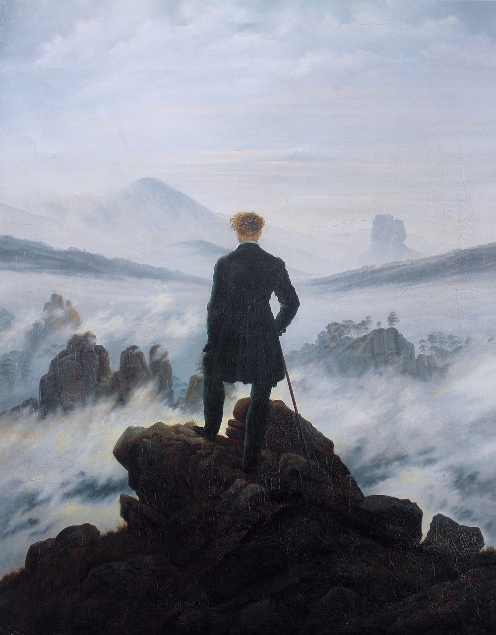 Caspar David Friedrich's painting Wanderer above the Sea of Fog: a lone figure seen from behind, standing on a rocky peak, looking out over a landscape drowned in fog