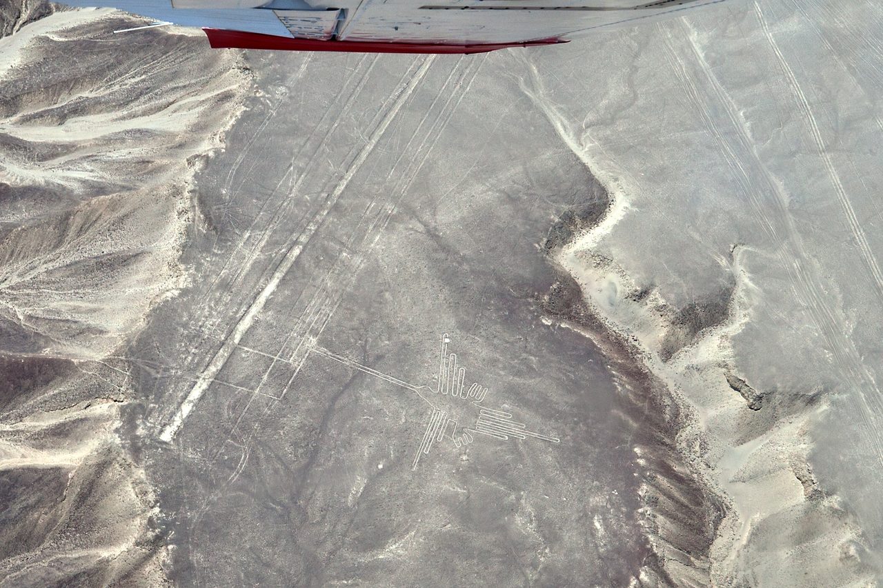 Aerial view of the Nazca hummingbird geoglyph, a long-beaked bird outlined by pale lines scraped into the desert
