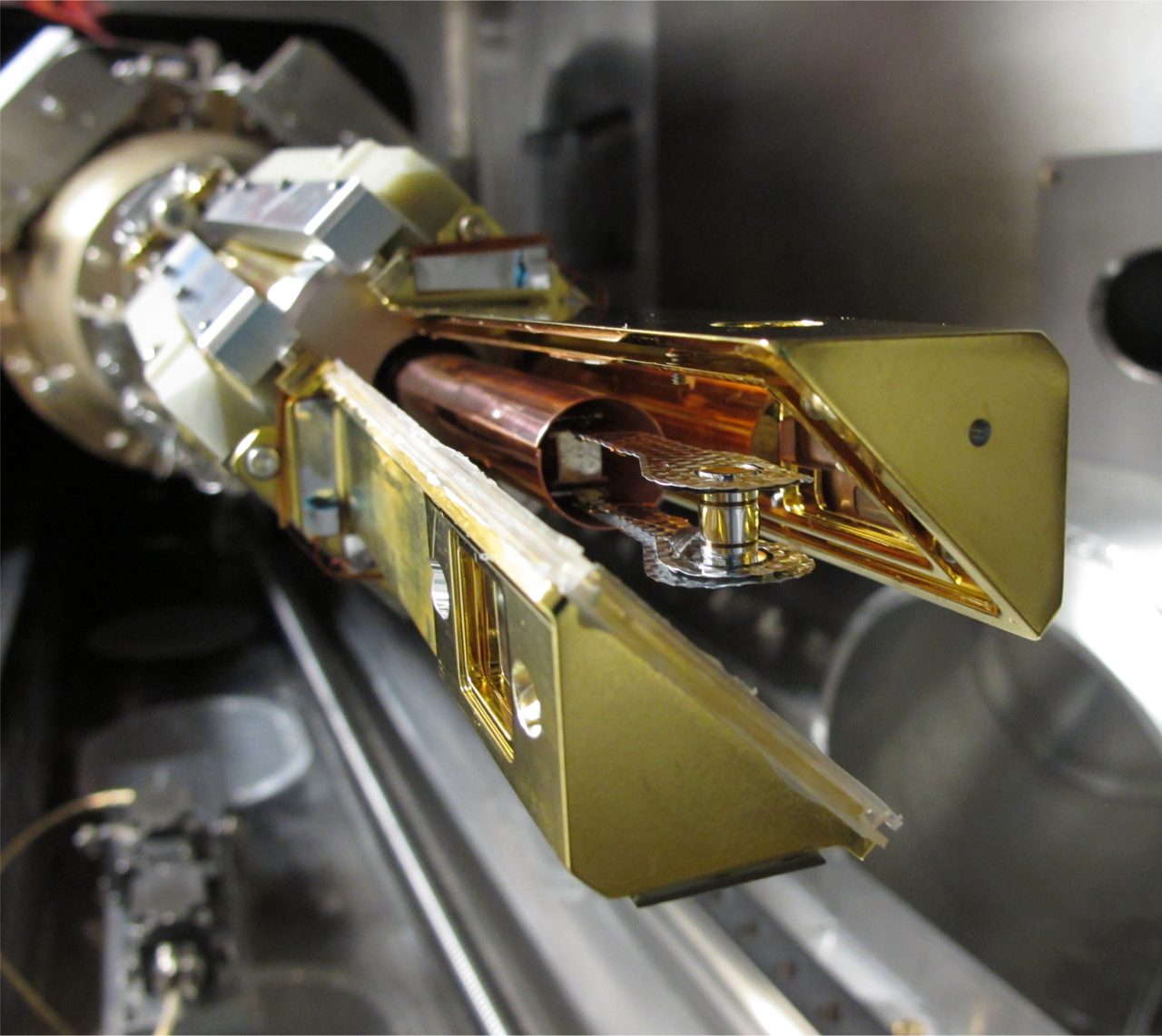 A cryogenic target assembly for an NIF ignition experiment, mounted in the target positioning system with two triangle-shaped shroud arms