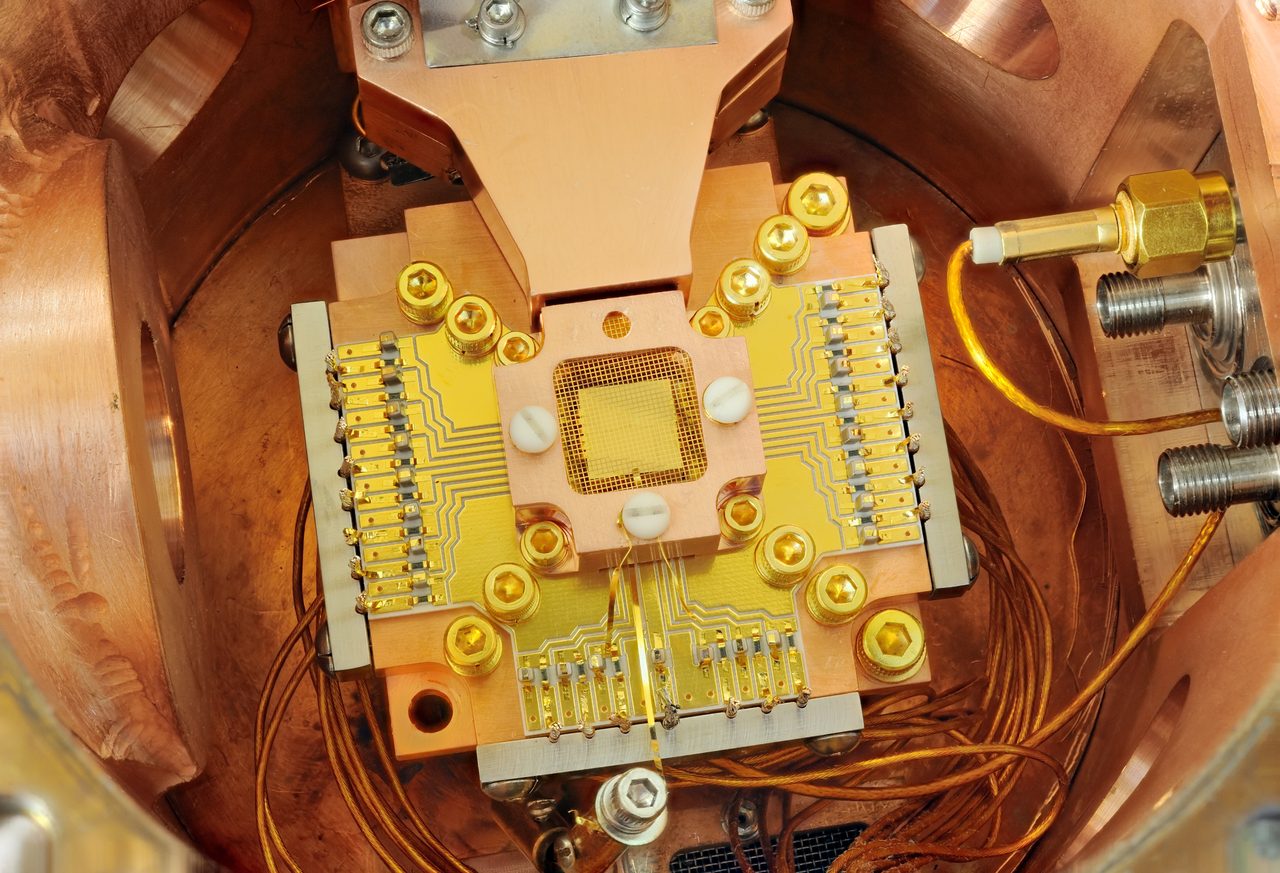 A NIST laboratory apparatus with a gold-plated ion-trap chip inside a copper enclosure with gold mesh shielding