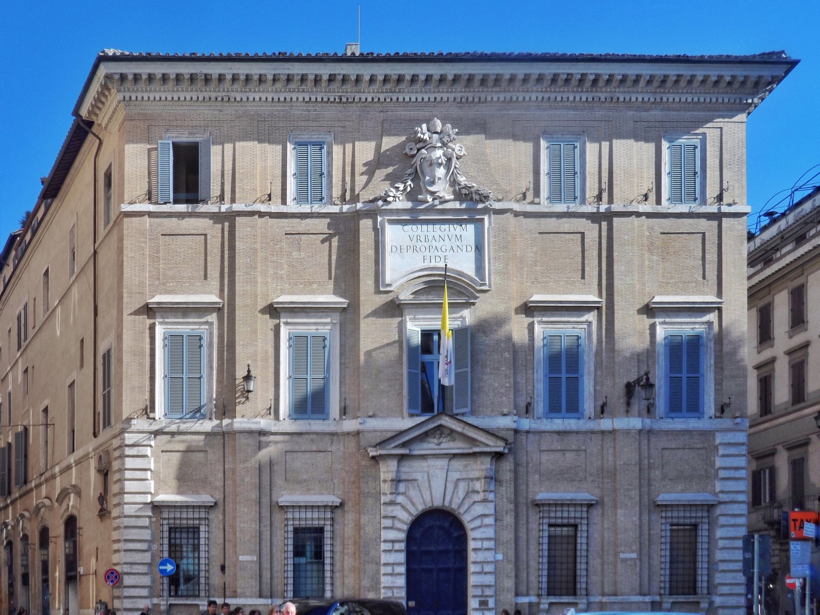 The stone facade of the Palazzo di Propaganda Fide in Rome, a grand 17th-century Baroque palace, seen from the street