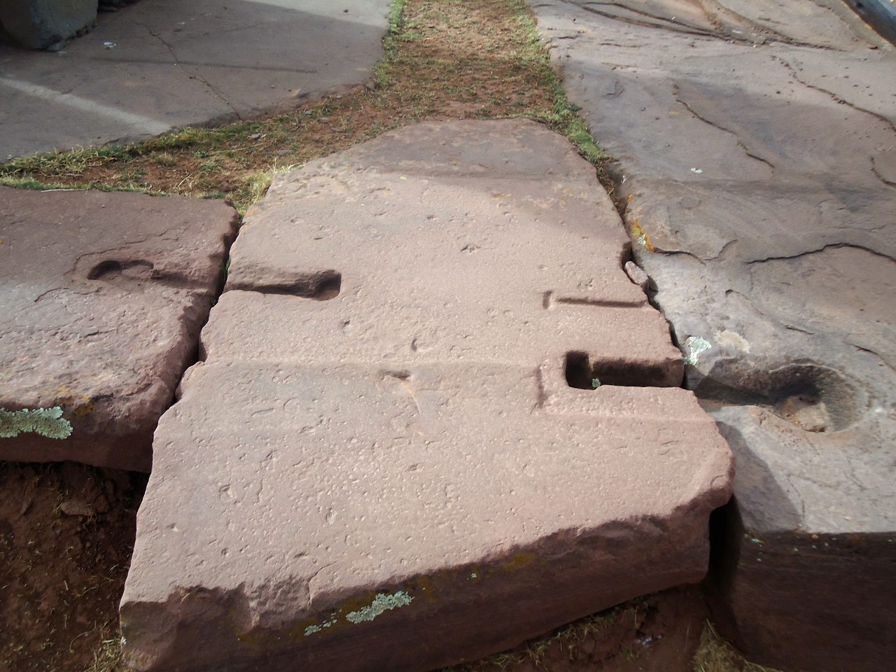 A red sandstone foundation block at Puma Punku with a carved I-shaped channel for a metal clamp