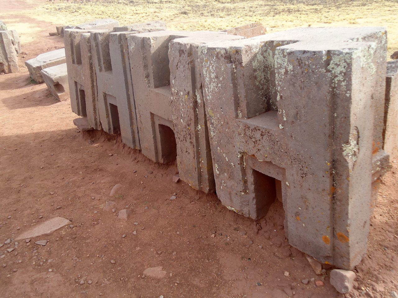 Close view of H-profile blocks at Puma Punku showing flat faces and crisp right-angle recesses