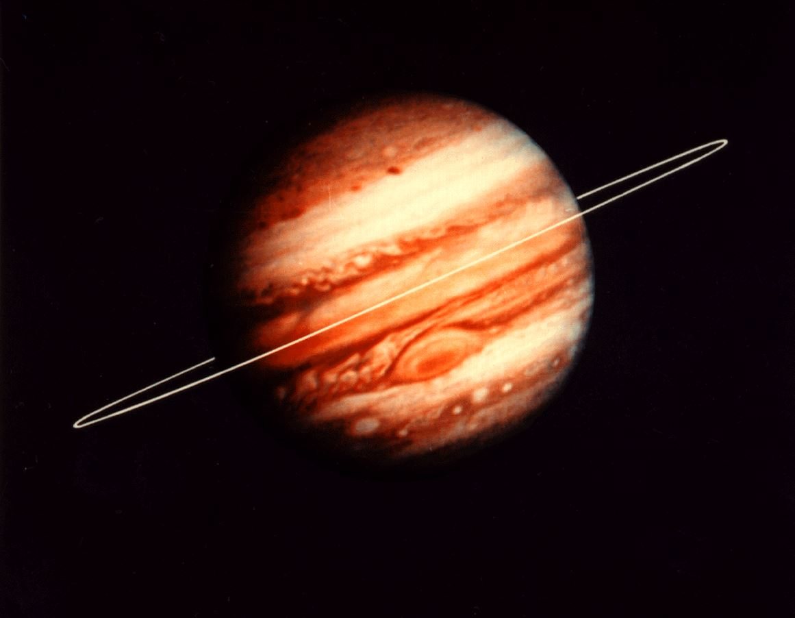 A full-disk NASA image of Jupiter, its cloud bands and Great Red Spot visible, with a thin white ellipse drawn on to mark the location of the planet's faint ring