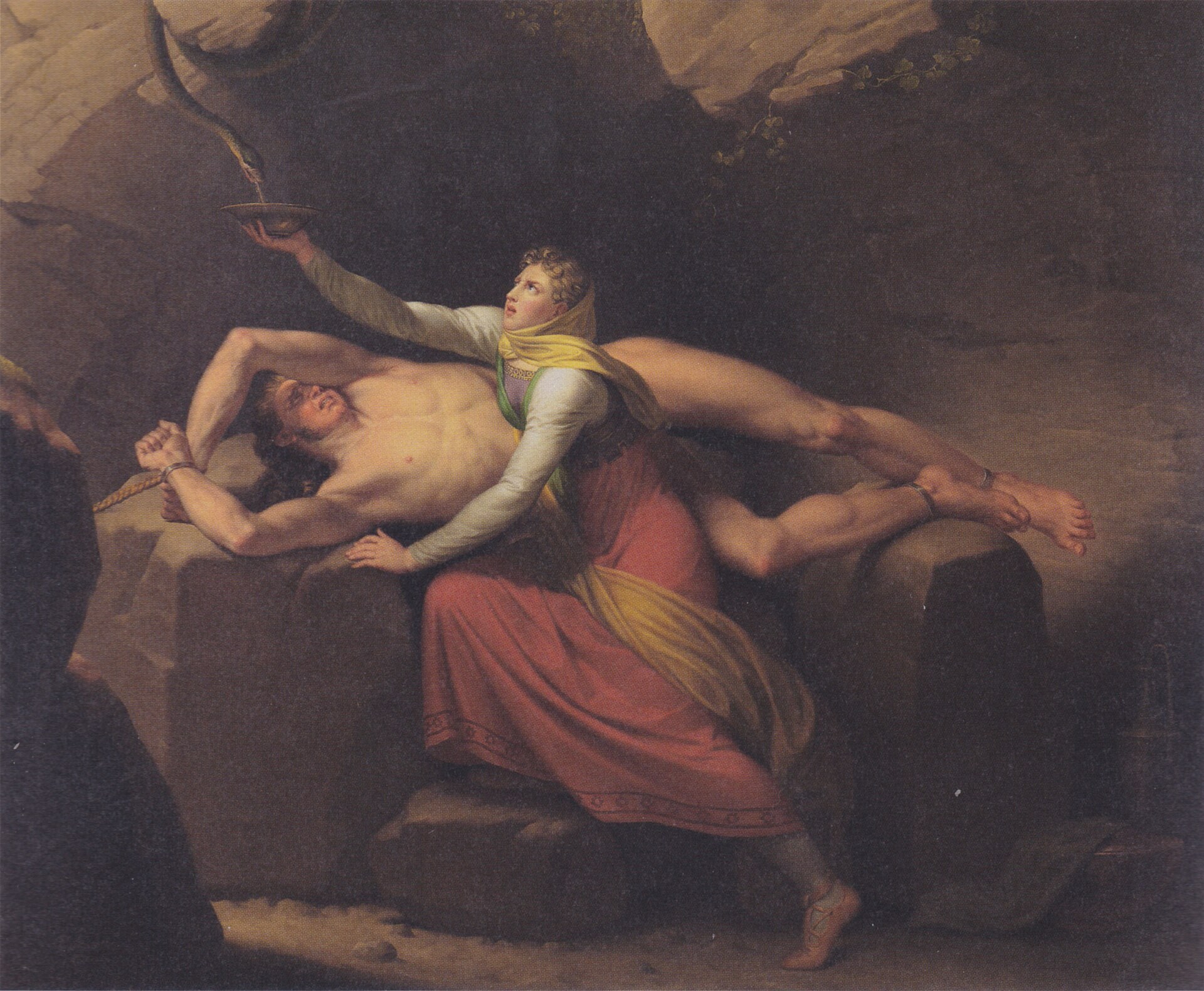 An oil painting of the bound Norse god Loki lying back across dark rock with his wrists and ankles shackled and splayed and his head tilted back, while his wife Sigyn in a red robe kneels over him reaching a shallow bowl up toward a serpent overhead