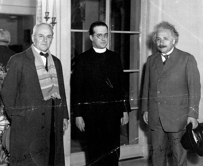 A black-and-white 1933 photograph of three men standing side by side: an older man in a coat at left, a younger man in a priest's clerical collar and round glasses in the center, and Albert Einstein with his distinctive hair at right holding a hat