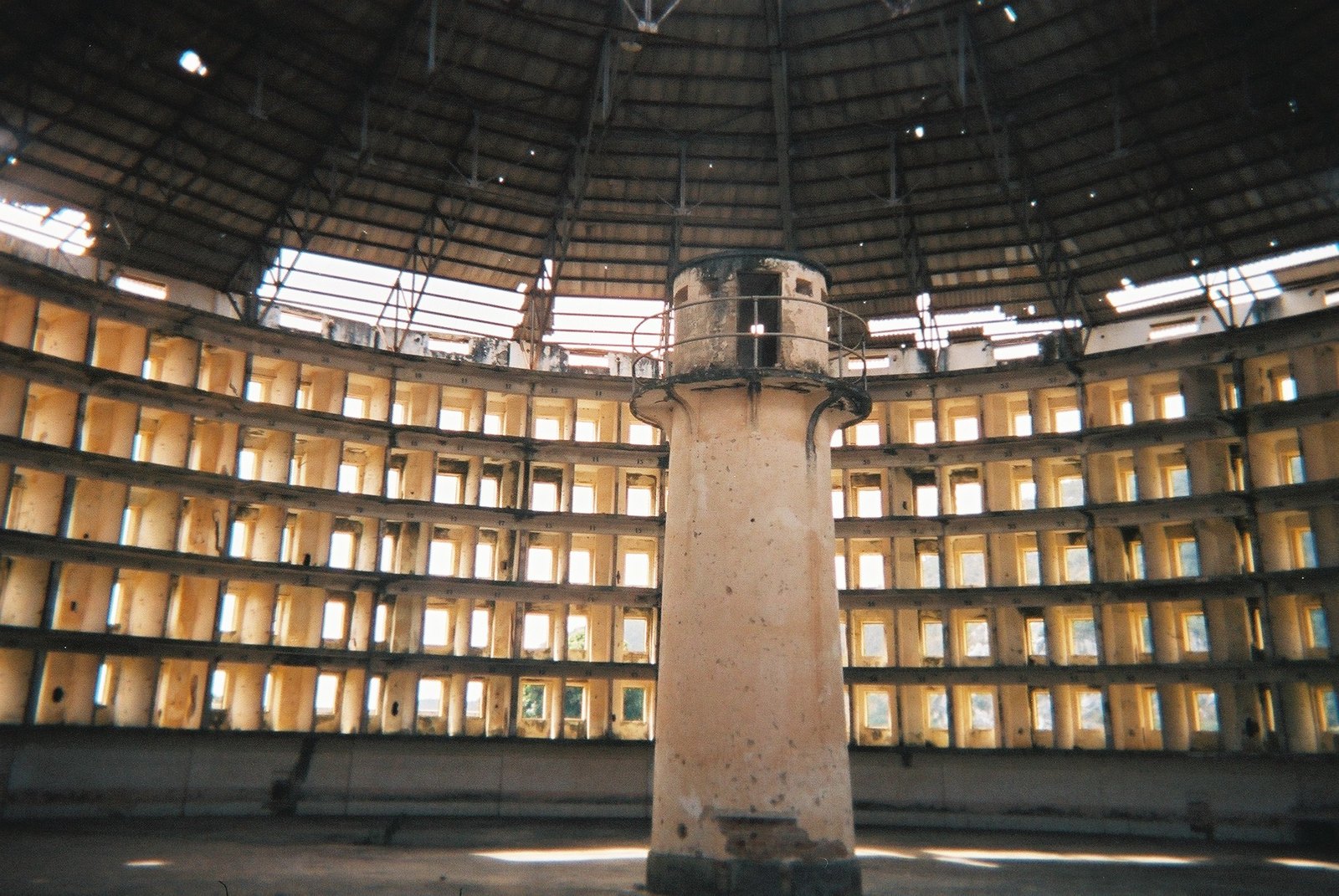 The vast circular interior of a Presidio Modelo cell block in Cuba: a single cylindrical inspection tower stands at the center of a huge round hall, ringed by tier upon tier of open cell doorways rising all the way around beneath a domed roof