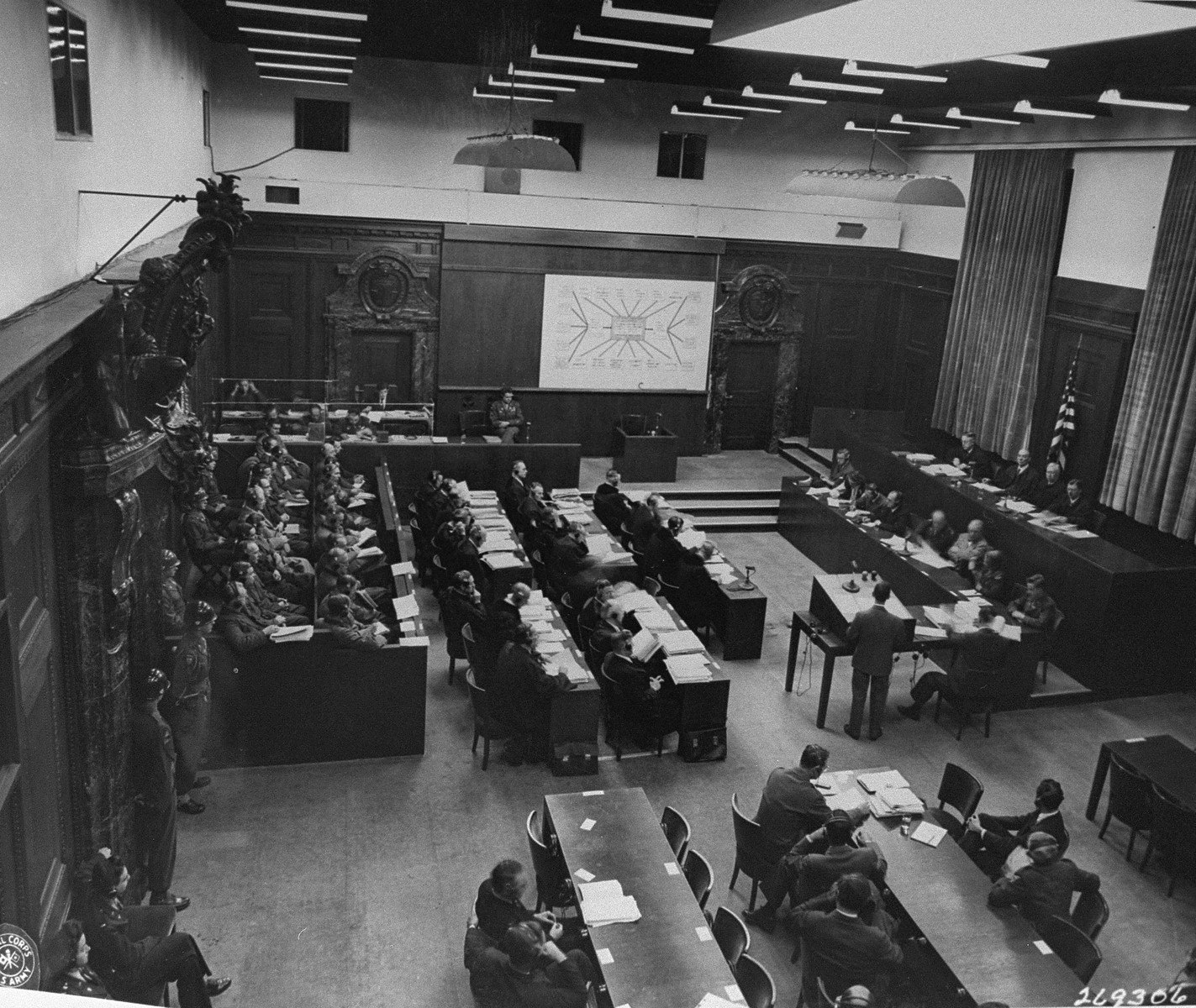 A black-and-white photograph of the Doctors' Trial courtroom in session at Nuremberg in 1946-47: the panel of American judges on a raised bench, the defendants and their counsel, and court staff arranged across a formal military courtroom