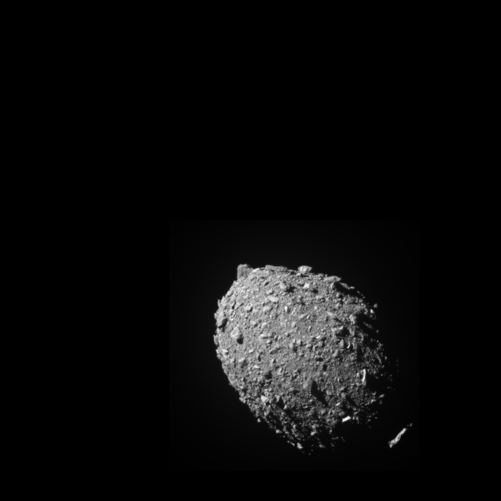 A grey rubble-covered asteroid, egg-shaped and strewn with boulders and gravel, lit from the upper left against black space, the image data occupying an inset region of a larger black frame