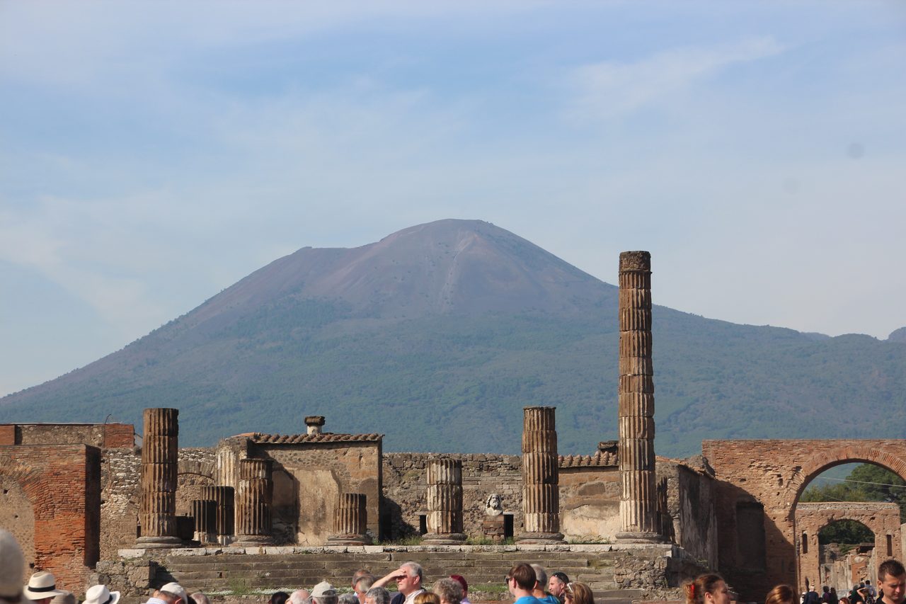 The colonnaded ruins of the Forum of Pompeii with Mount Vesuvius rising in the background