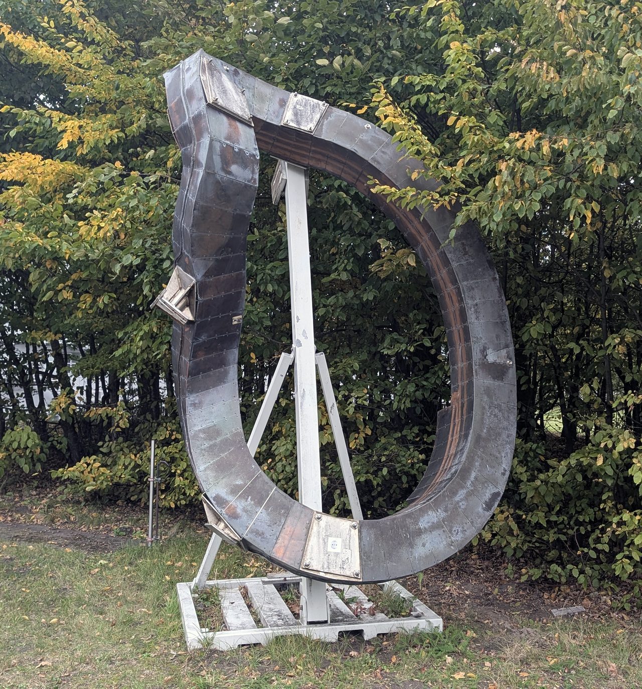 A single non-planar, twisted superconducting coil from the Wendelstein 7-X stellarator, displayed as an outdoor exhibit piece