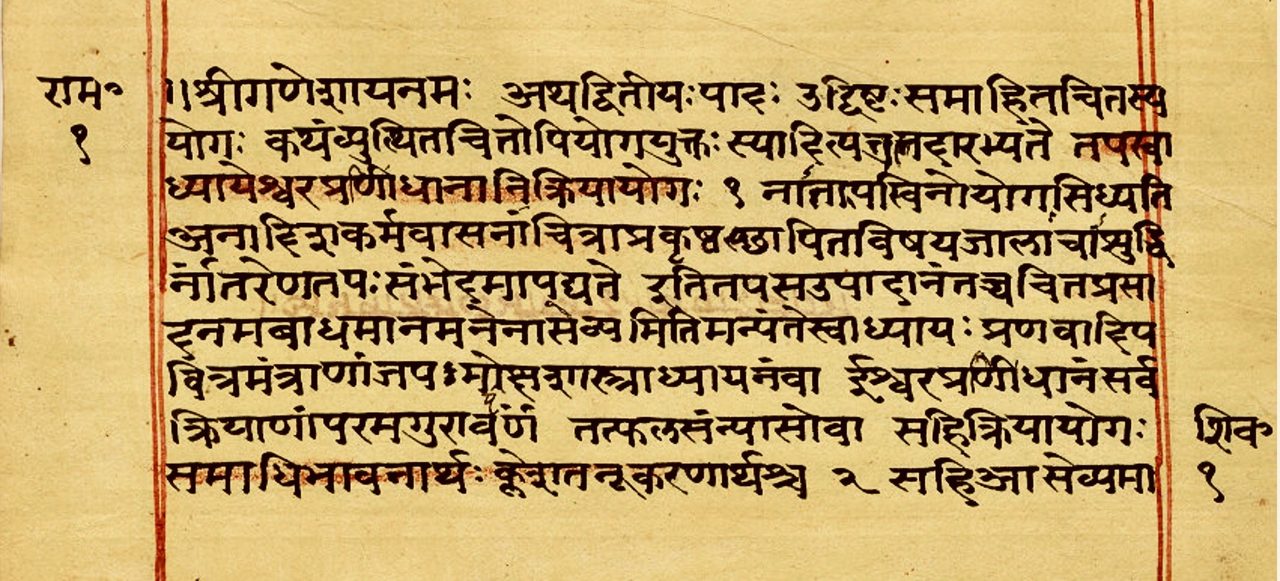 A wide folio from a Sanskrit manuscript in Devanagari script, ruled in red down both margins, with several lines washed over in orange saffron powder